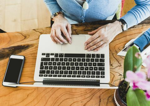 Close-up de mulher com smartphone e laptop na mesa