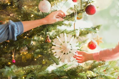 Mãe e filha pendurado ornamento de floco de neve na árvore de Natal