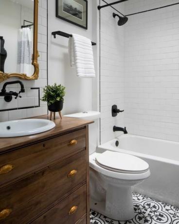 banheiro branco, pia e gavetas de madeira, torneiras pretas e detalhes