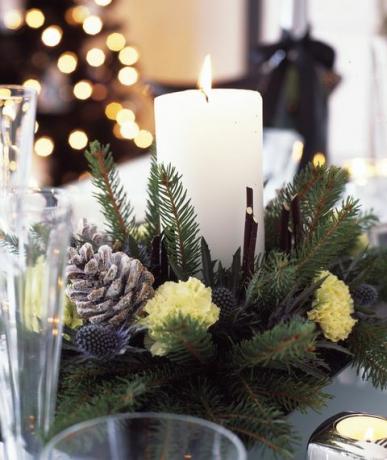 decorações de natal em preto e branco com prata e violeta forsted para casa, mesa de jantar com centro de vela feita com galhos recém-cortados, pinhas e cravos