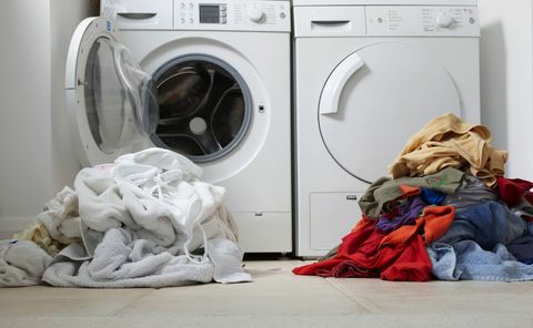 Pilha de roupa e máquina de lavar e secar roupa