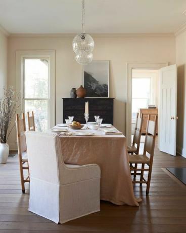 mesa de jantar, toalha de mesa rosa empoeirada, cadeiras de jantar de madeira, cadeiras de apoio de material branco, lareira