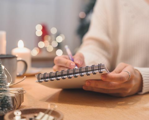 metas, planos, tarefas a fazer e lista de desejos para o ano novo Natal conceito escrevendo no caderno, mulher, segurando a caneta no bloco de notas em casa nas férias de inverno natal