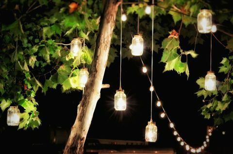 Decorações iluminadas penduradas em uma árvore em um jardim à noite