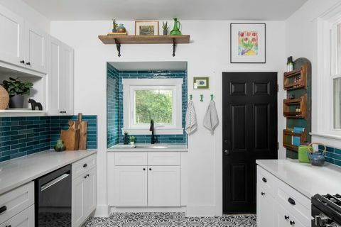 cozinha, armários brancos, porta preta, backsplash de azulejos de metrô azul-petróleo