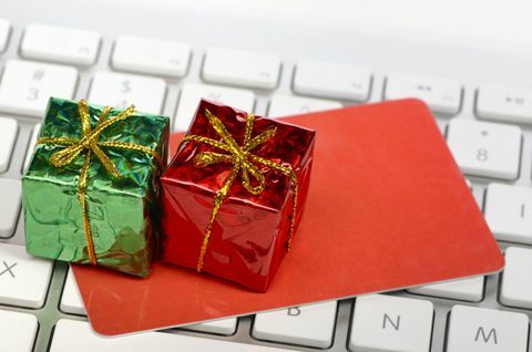 Compras on-line do conceito de férias - caixas de presente em miniatura e cartão de crédito ou presente em cima do teclado do computador.