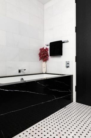banheira de mármore preto, azulejos quadrados brancos e pretos