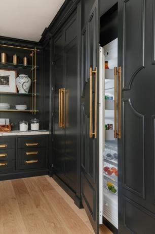 uma cozinha com uma geladeira preta
