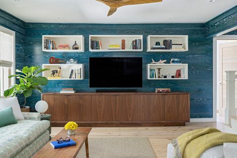sala de estar, revestimento de parede azul, papel de parede azul, console de mídia com tv HD no topo, ventilador de teto de madeira, cubículos brancos