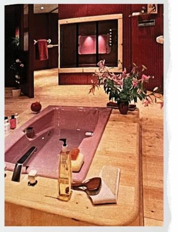 banheira rosa em um banheiro com piso de madeira