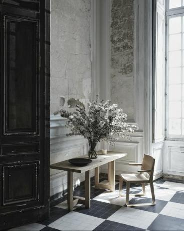 mesa e cadeira com flores em vaso em cima da mesa