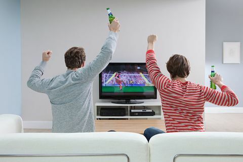 Dois homens assistindo futebol na televisão