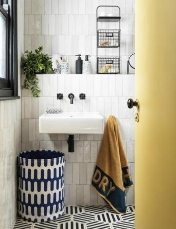 banheiro com despensa e azulejos brancos