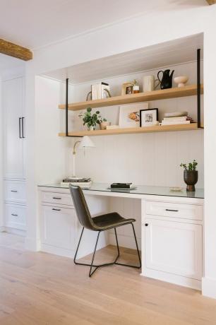 uma cozinha branca com uma cadeira preta
