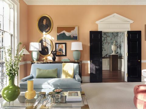 sala de estar, papel de parede laranja, portas pretas, sofá azul, vaso amarelo e verde