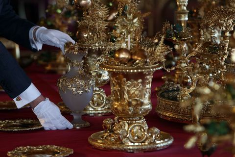 A mesa de jantar está posta com peças douradas do Grand Service
