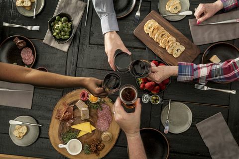 Visão aérea de amigos que compartilham uma refeição: Amigos que compartilham charcutaria e tapas com vinho e cerveja.
