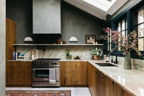 cozinha com armários de madeira, janela verde, bancada de mármore e backsplash,