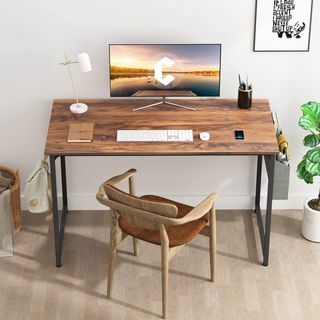 área de home office com mesa de nogueira com computador e lâmpada