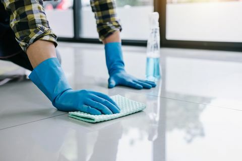 Homem limpando o chão de azulejos
