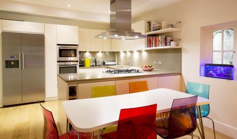Cozinha moderna, incluindo cadeiras coloridas na mesa de jantar