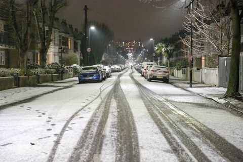 Uma estrada vista coberta de neve no norte de Londres ...