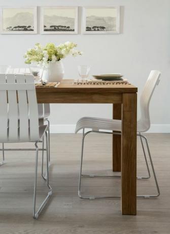 Cadeiras brancas na mesa de jantar de madeira