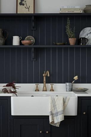 cozinha azul marinho com pequena prateleira acima