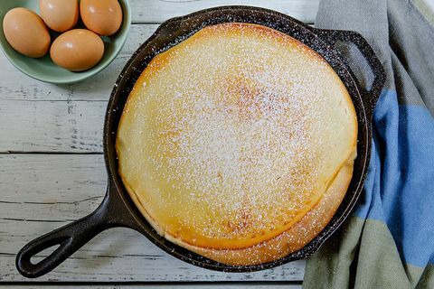 Panqueca na frigideira perto de tigela de ovos em cima da mesa